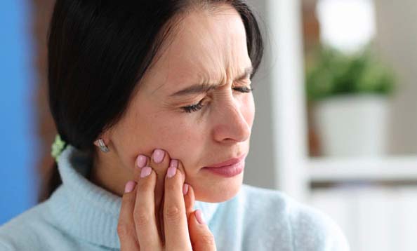 Woman suffering from jaw pain